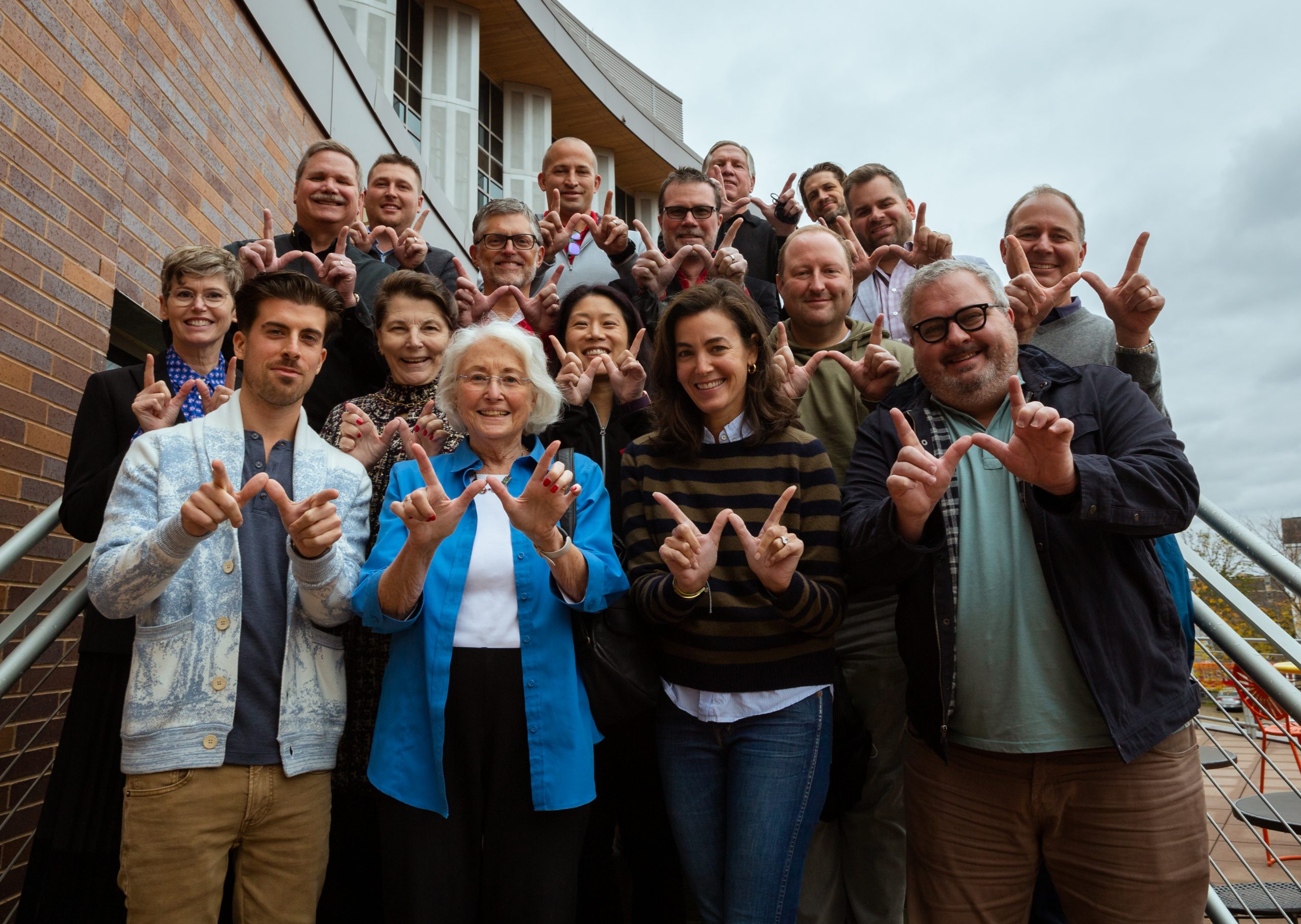 Group of CAPS board members holding up W fingers. 